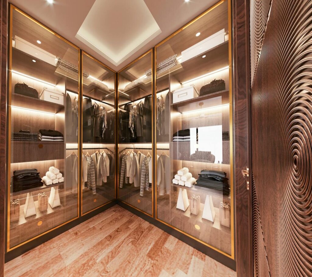 Elegant walk-in closet with glass doors, showcasing modern interior design and organized fashion storage.