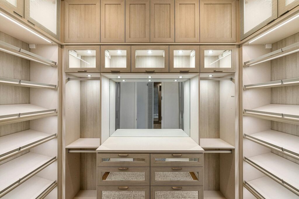 Spacious walk-in closet with wooden cabinets and ample lighting.